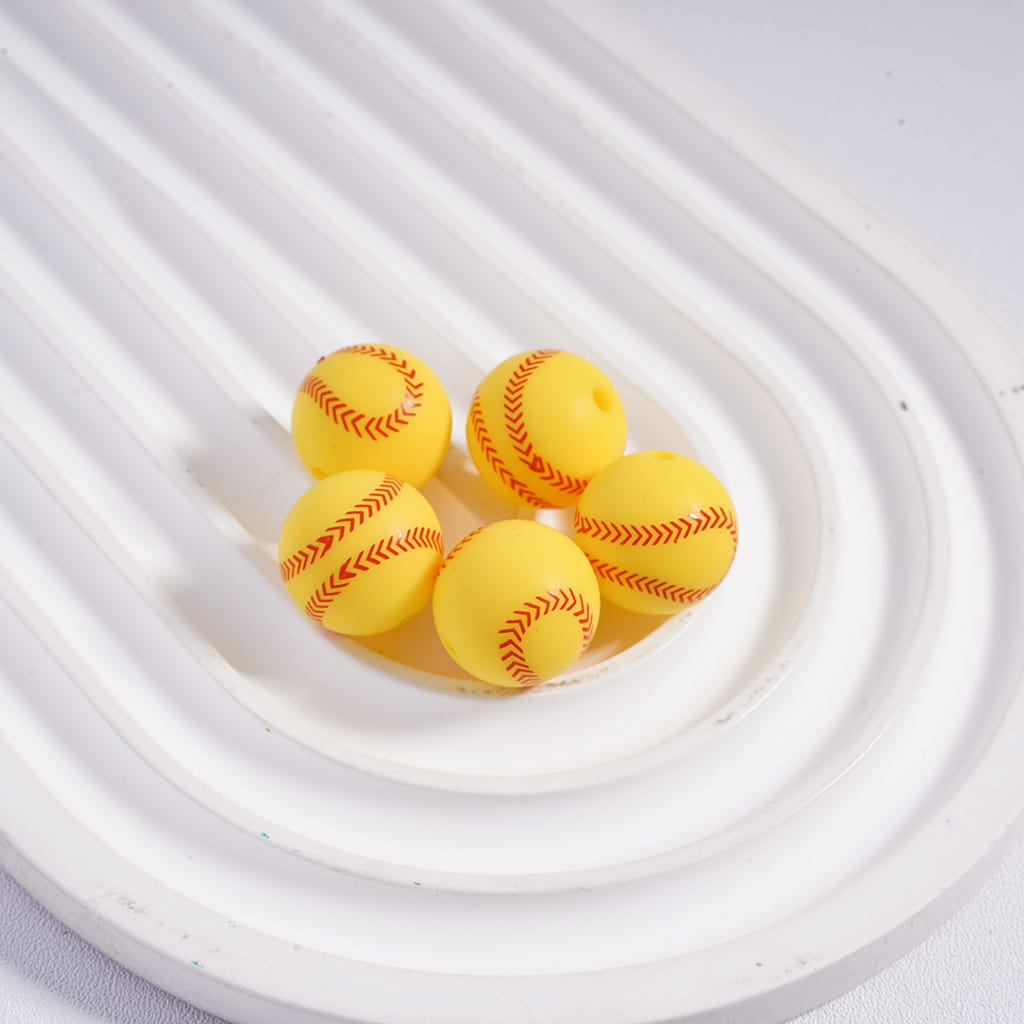 Yellow foam baseballs with red stitching on a white background