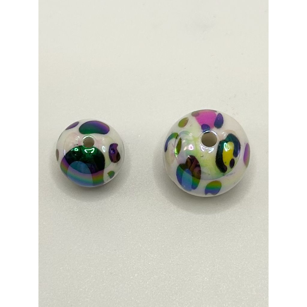 Two round beads with multicolored polka dot pattern on a white background