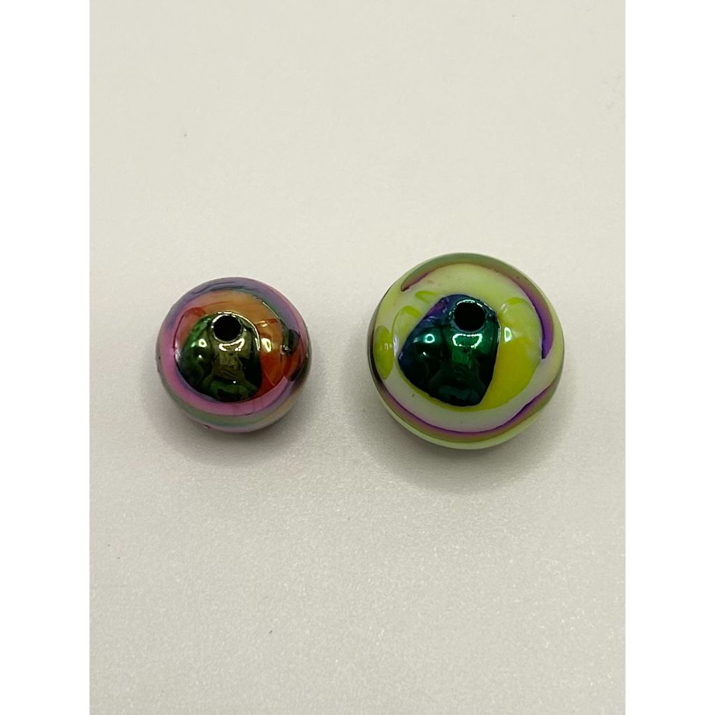 Two round, multicolored glass beads on a light gray background