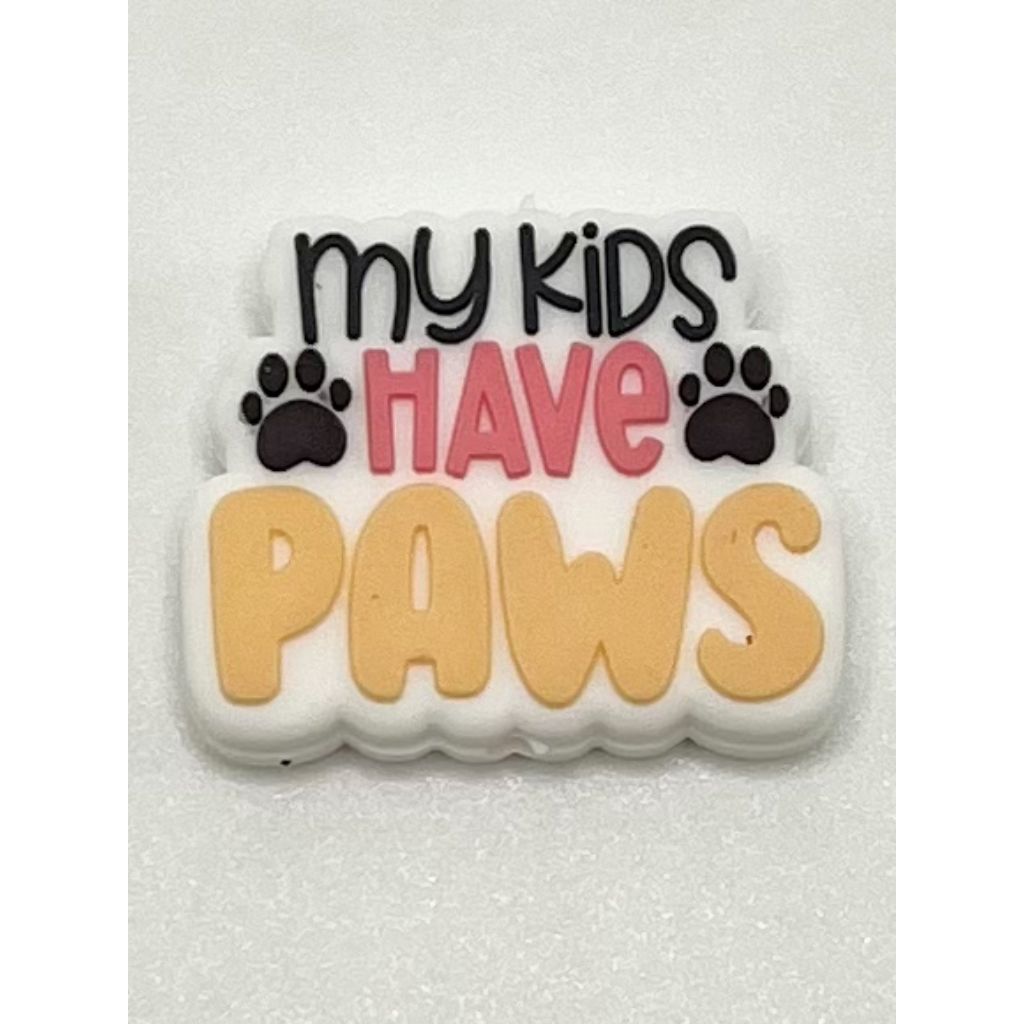 A silicone bead with the phrase 'My Kids Have Paws' printed on it, predominantly in beige color with black and red text, and black paw prints.
