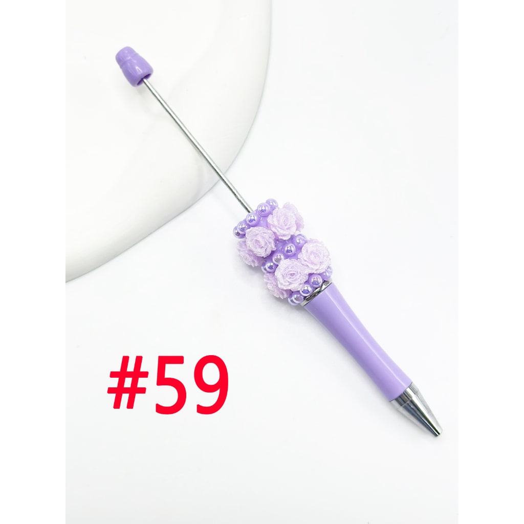 A selection of beadable pens with flower pearl embellishments in various solid and ombre colors.