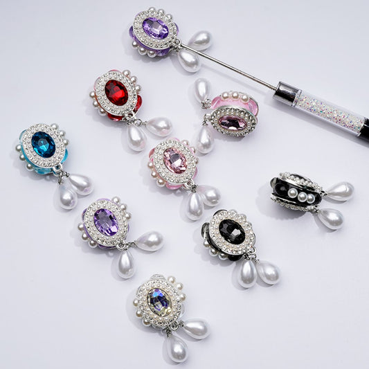 繊細なファンシーシルバー合金のオーバルシェイプフレーム。内側には大きなレッドラインストーン、ミニクリアラインストーン、ホワイトパールペンダント、クレイビーズ付き。約27×48mm。