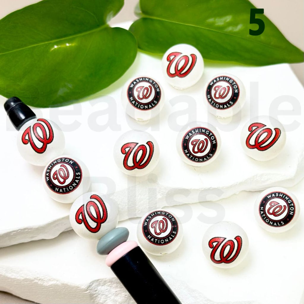Set of Washington Nationals nail art stickers on a white surface with green leaves in the background.