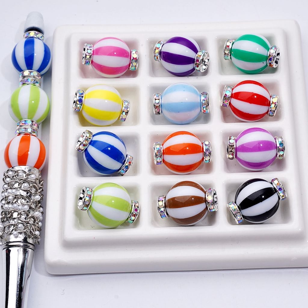 Set of colorful striped beads with a metal tool on a white background