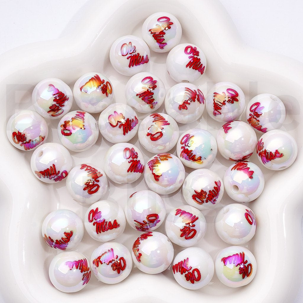 White beads with red and pink designs on a white plate