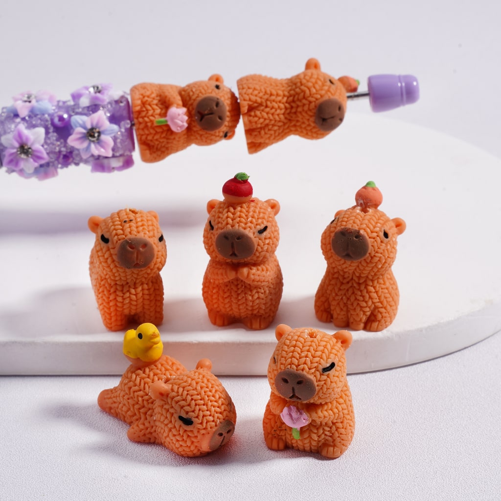 Set of small orange animal figurines with decorative elements on a white background