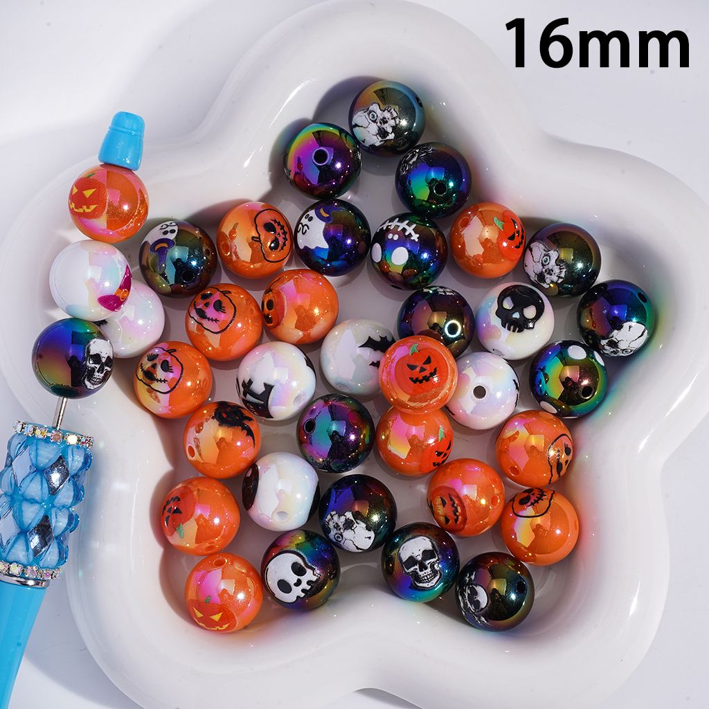 Assorted Halloween-themed beads in a white dish with a blue tool on a white background.