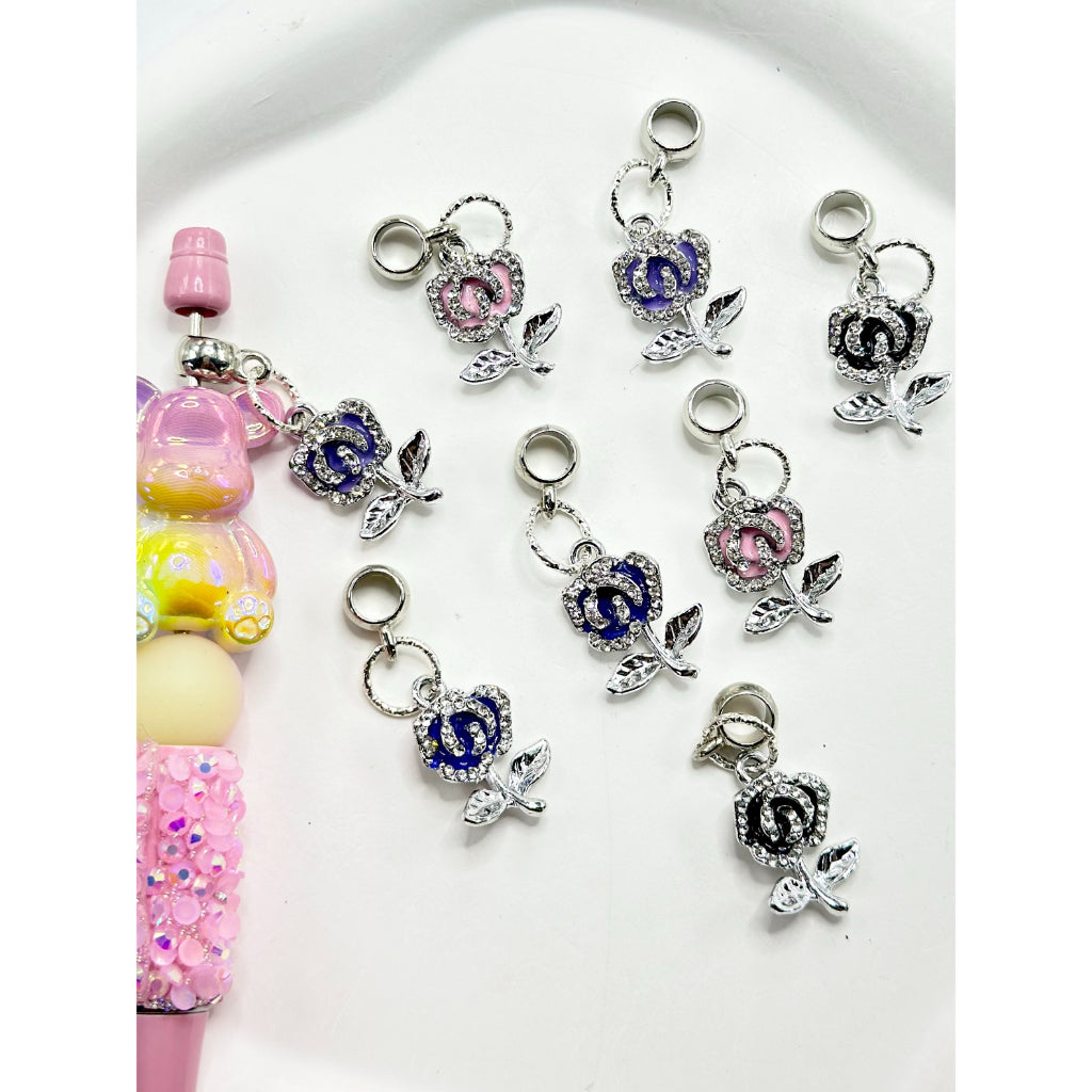 A collection of multicolored charm chains with rose alloy clear rhinestones intended for use with pens, displayed against a white background.