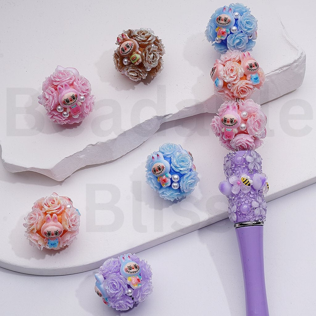Decorative pen with floral designs and small figurines on a white background