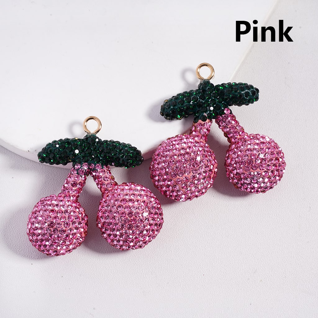 Pink cherry-shaped earrings with green leaves on a white background