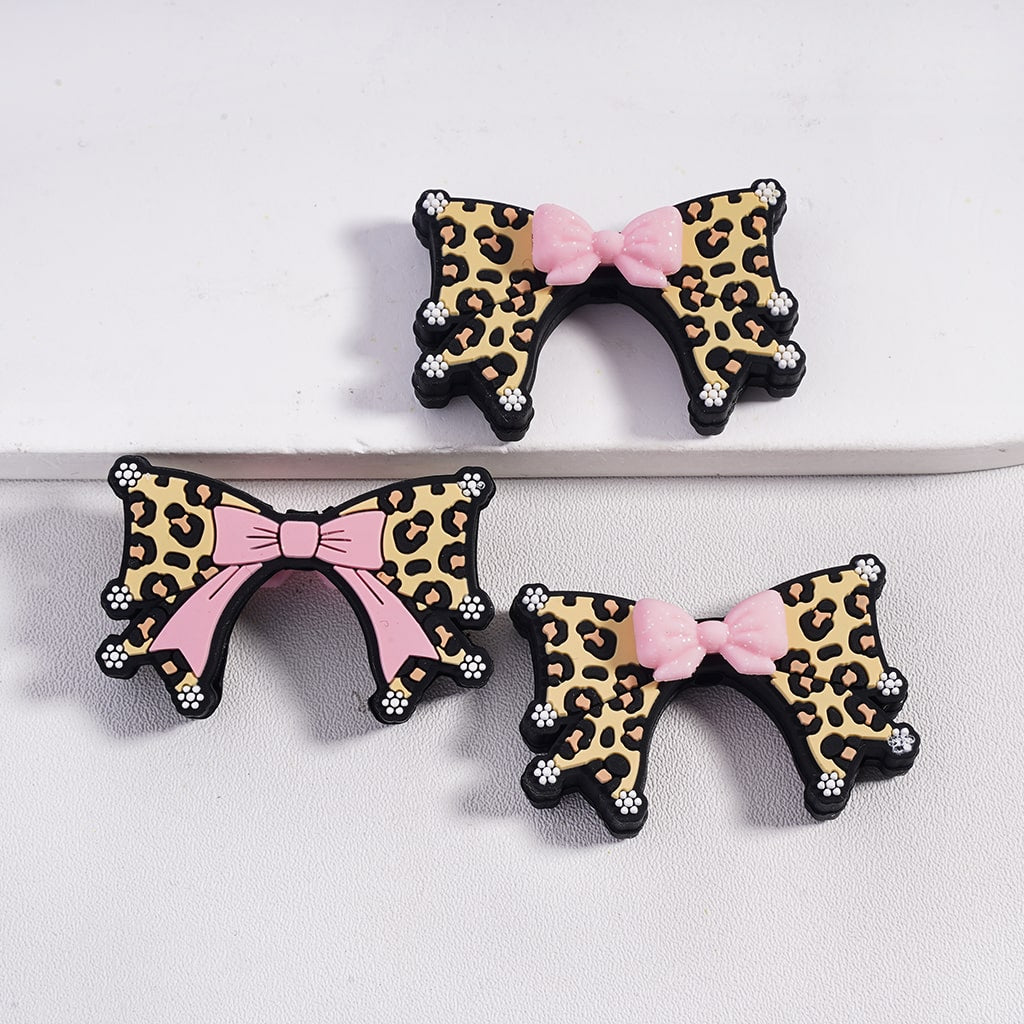 Leopard print hair bows with pink centers on a white background