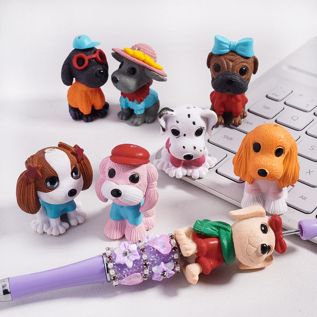 Set of small dog figurines with colorful accessories on a white surface.