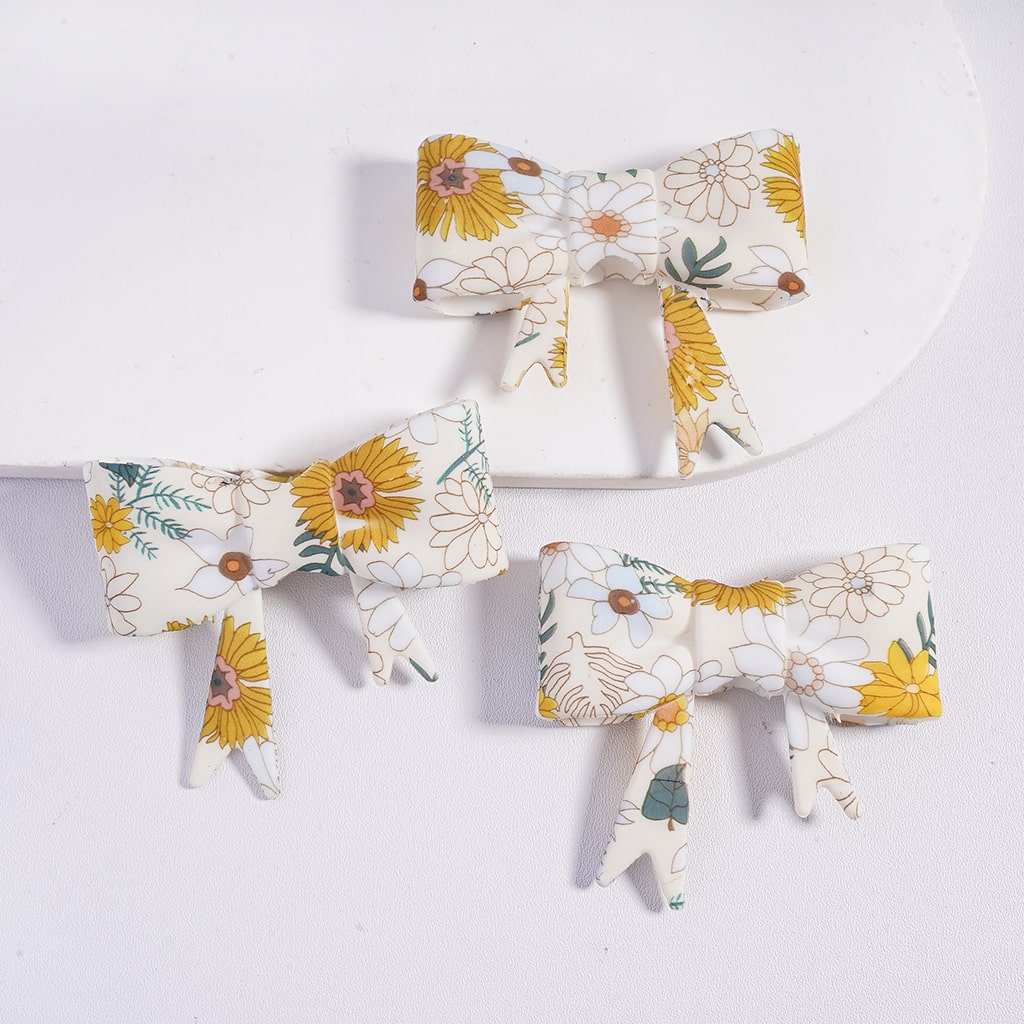 Three floral-patterned hair bows on a white background