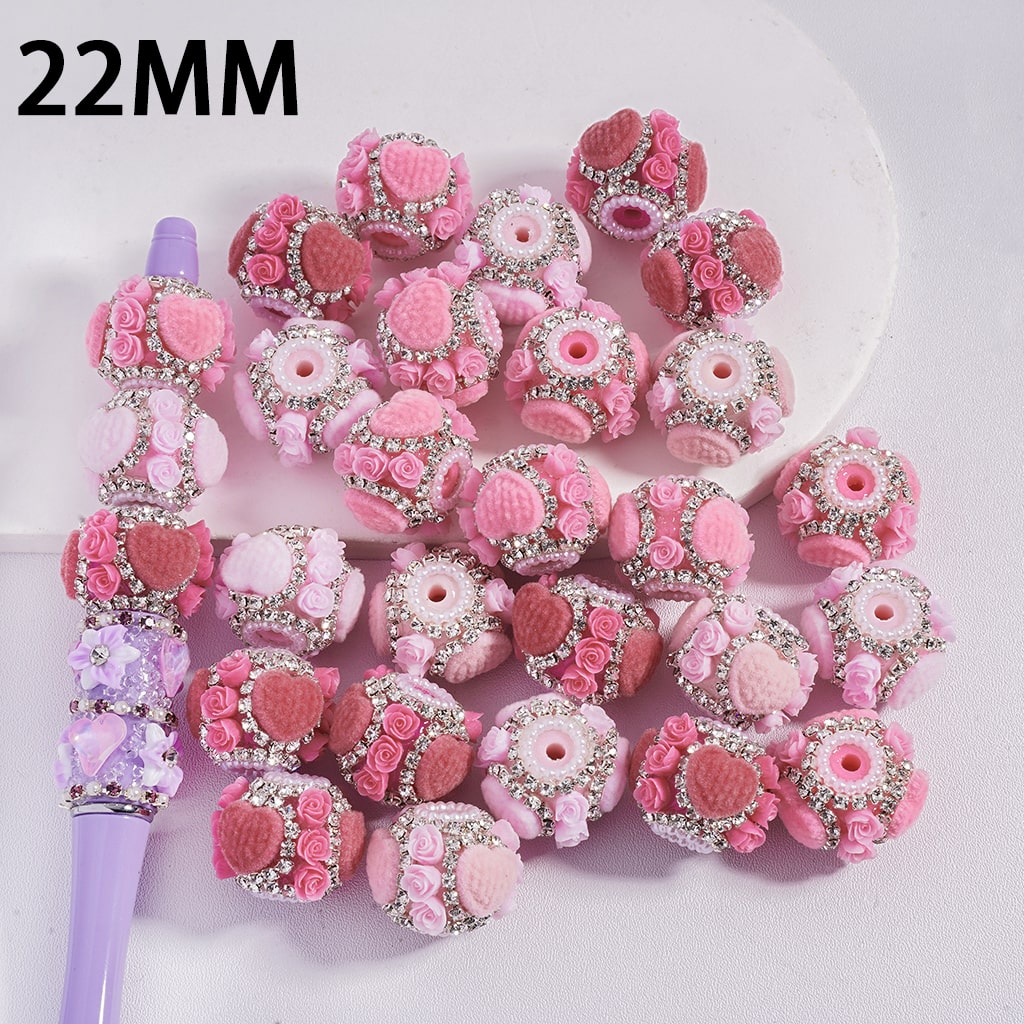 Pink and purple decorative beads with a pen on a white background, labeled '22MM'.