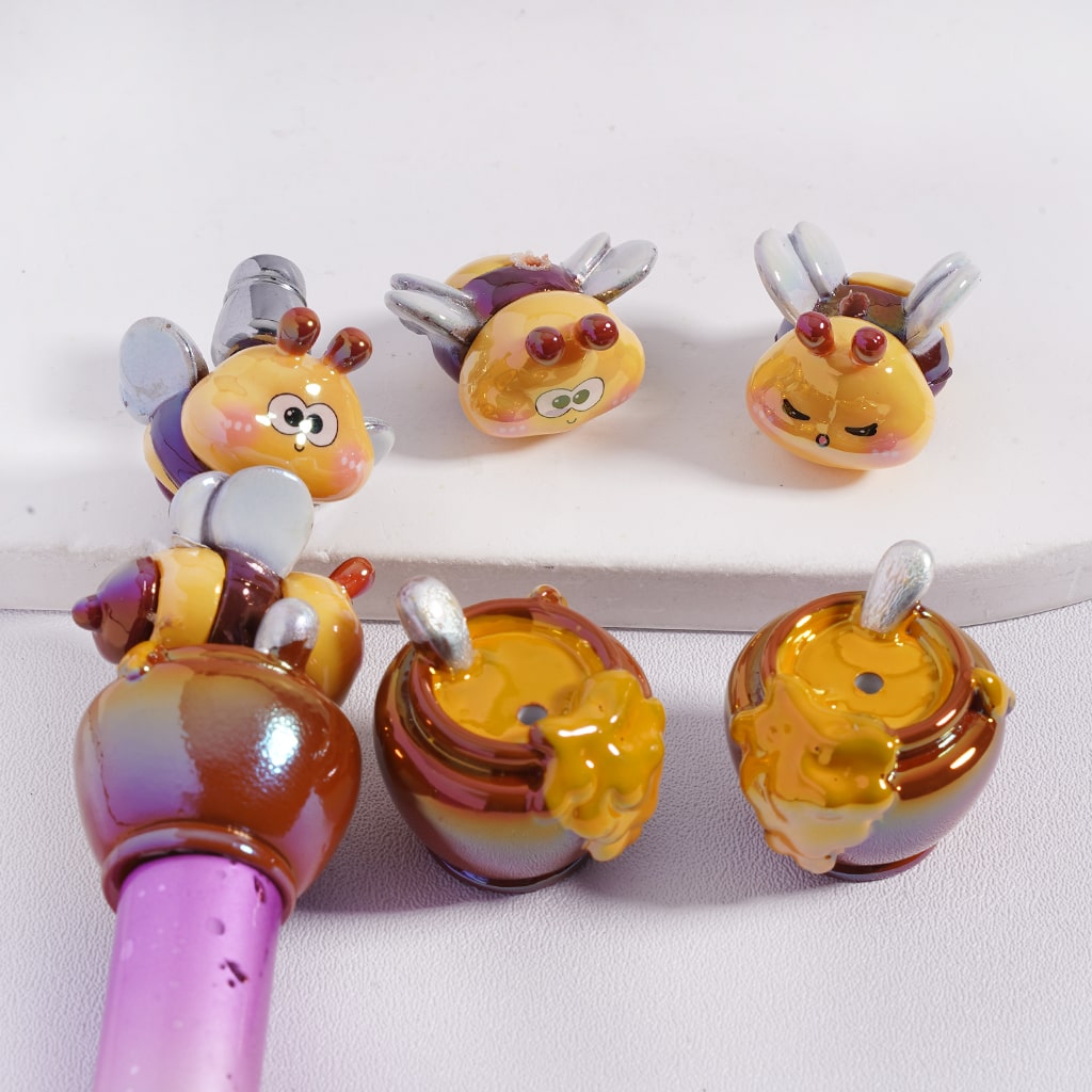 Colorful glass bee-shaped beads on a white surface