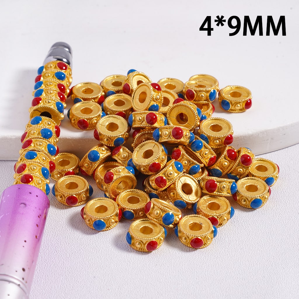 Gold beads with colorful accents on a white background