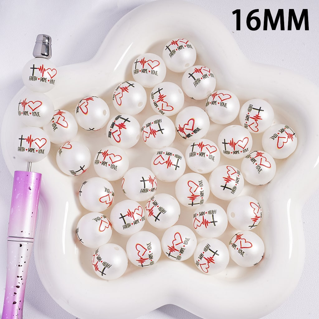 White beads with red and black designs on a white tray with a pink tool, labeled '16MM'.