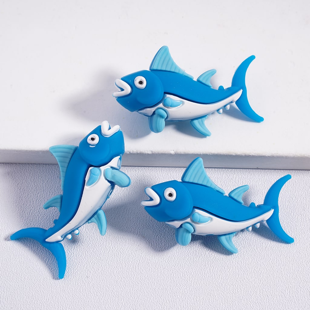 Three blue fish-shaped toys on a white background