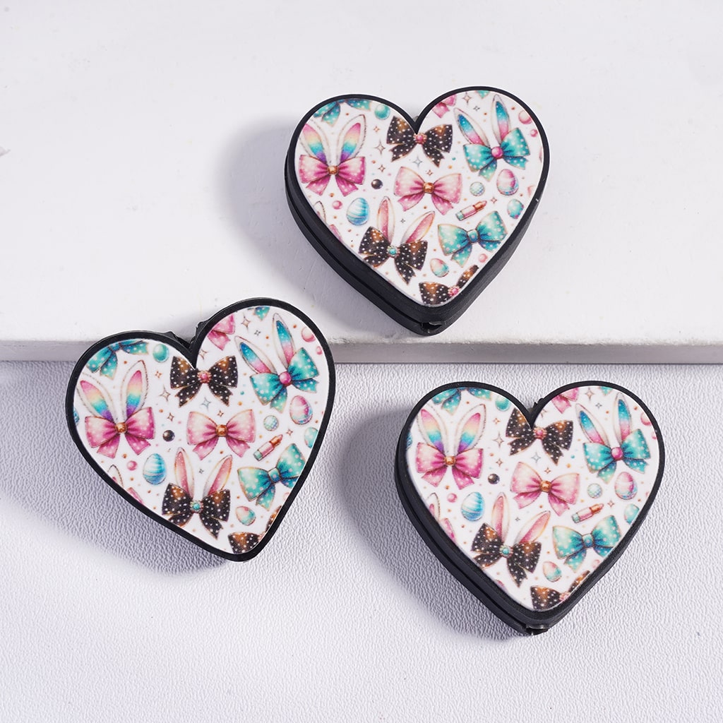 Three heart-shaped containers with butterfly and bow design on a white background