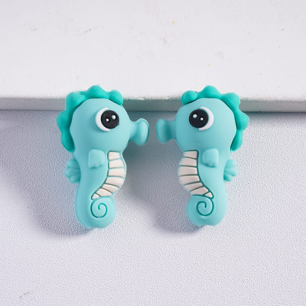 Two turquoise seahorse-shaped objects on a light gray background