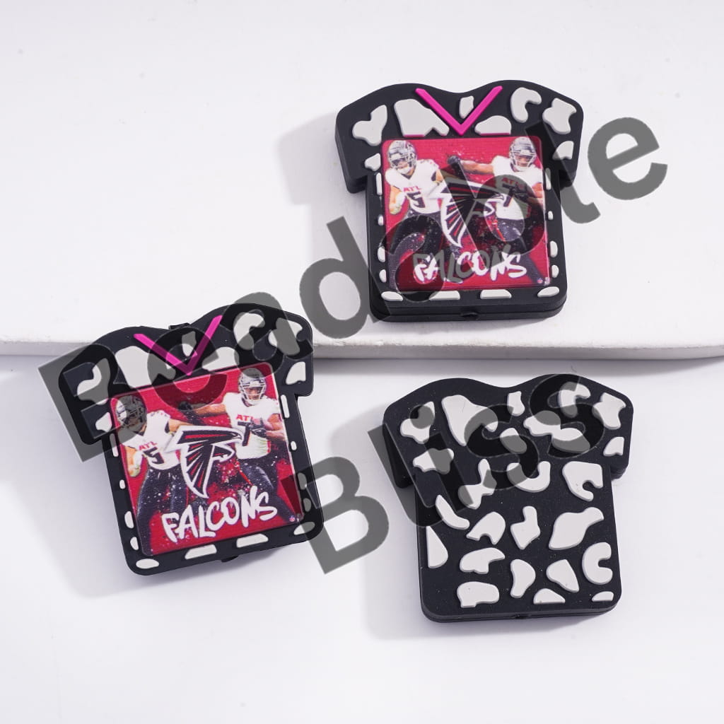 Three decorative pins with 'Falcons' branding on a white background