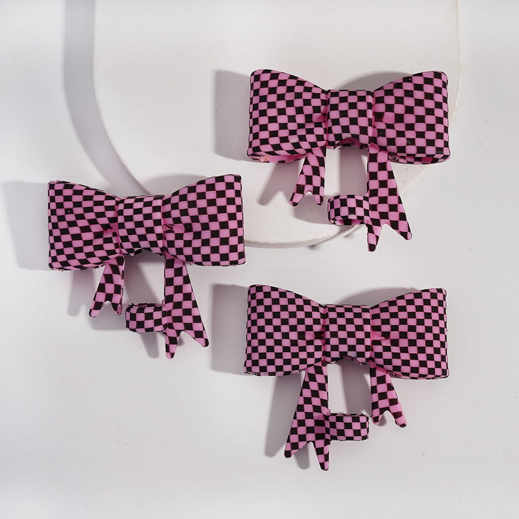 Set of pink and black checkered bows on a white background