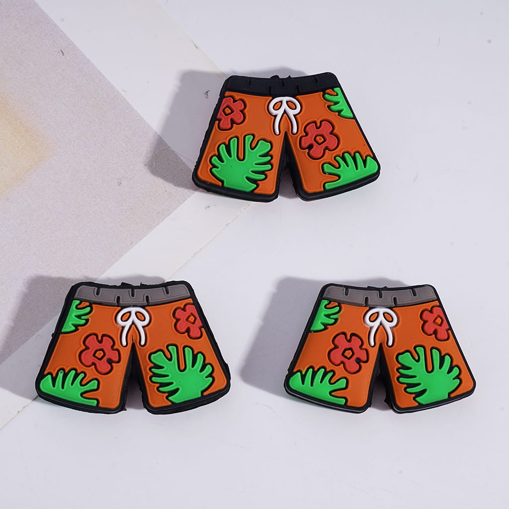 Shorts-shaped earrings with floral and leaf designs on a white background