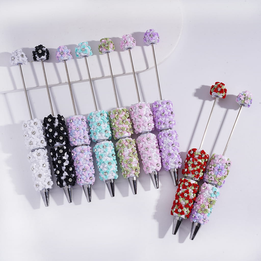 Decorative pens with colorful bead caps on a white background