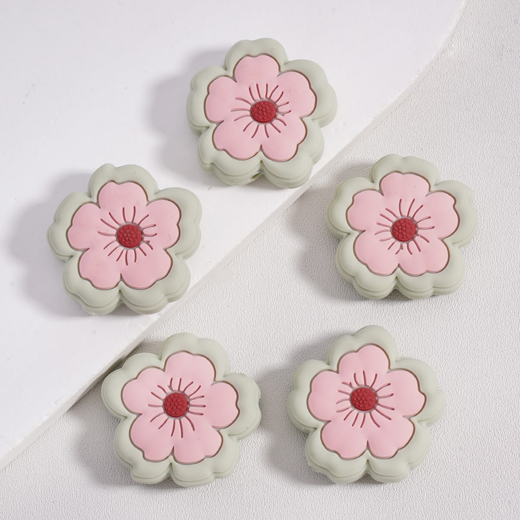 Five flower-shaped objects with pink centers and green outlines on a white background