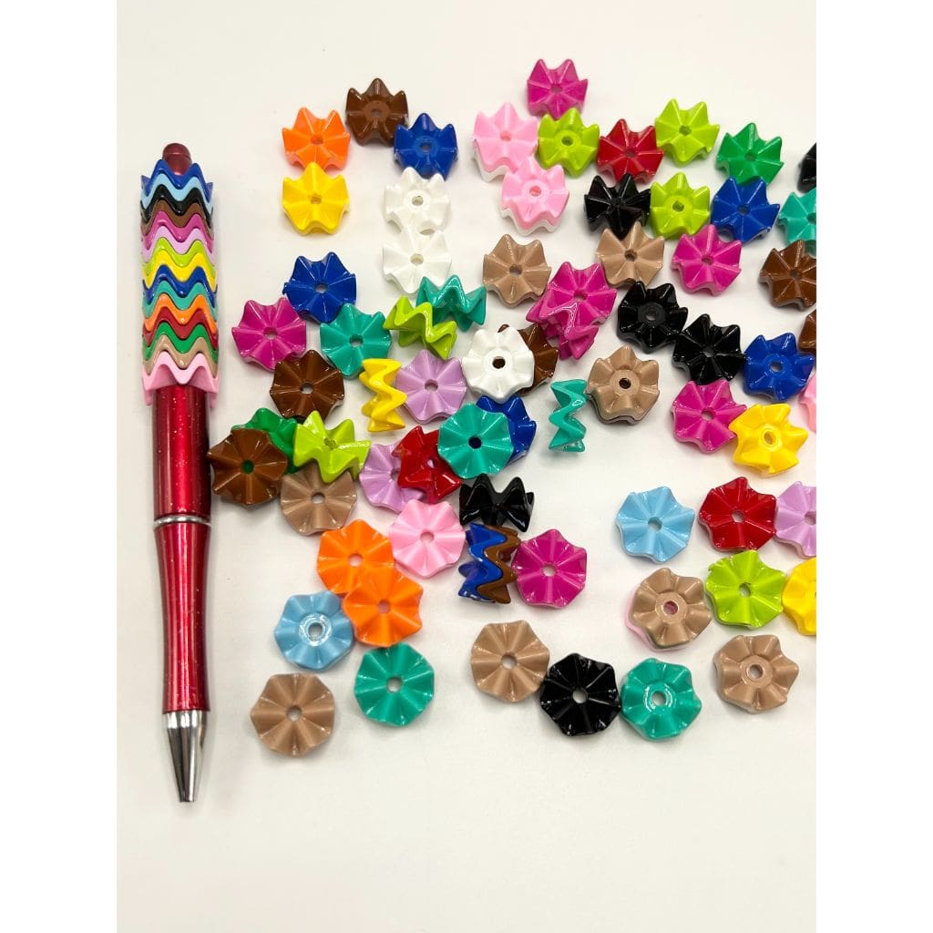 Colorful flower-shaped buttons and a pen on a white background
