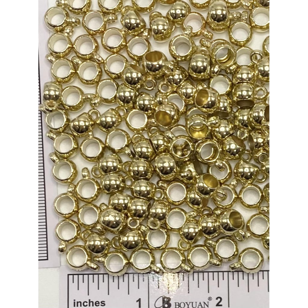 Two sets of bail beads for charms and pendants, one in silver color and the other in gold tone, displayed on a ruler for scale.