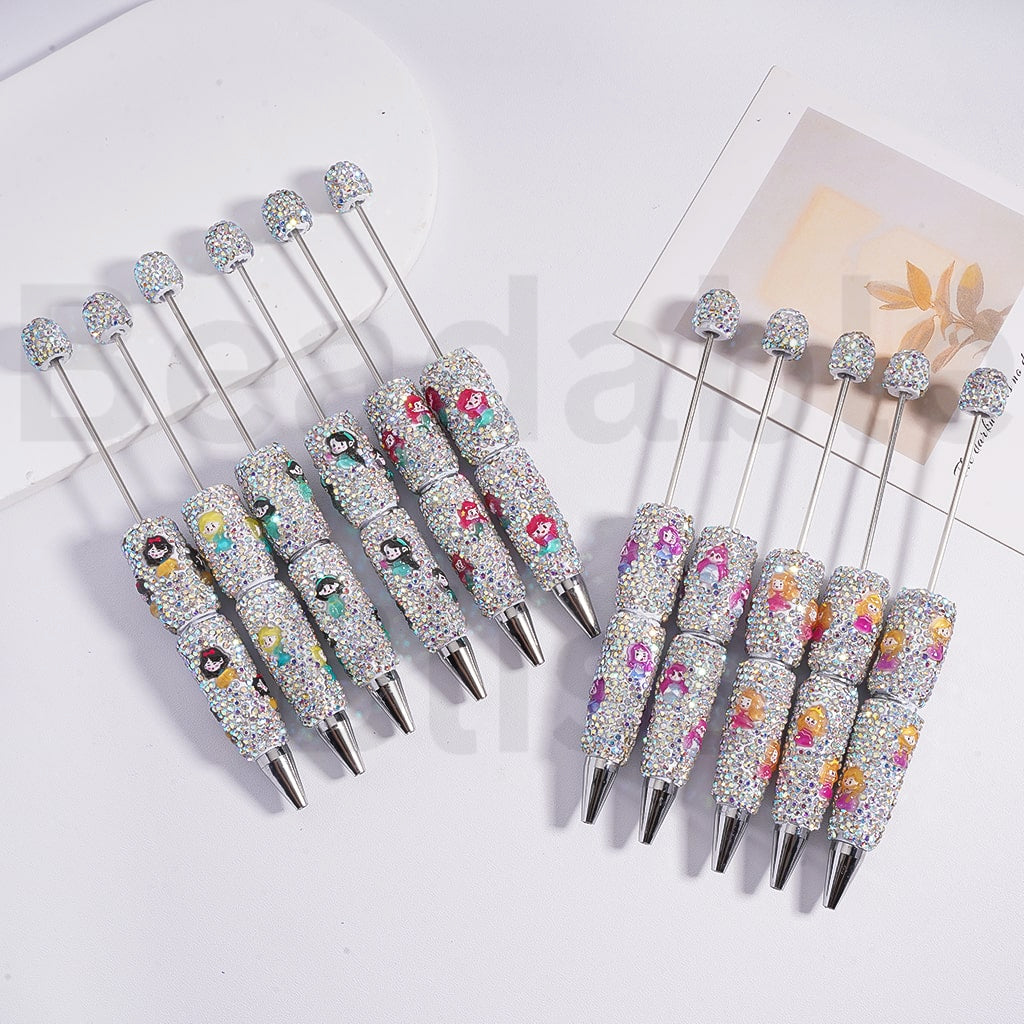 Set of decorative pens with floral designs and rhinestones on a white background