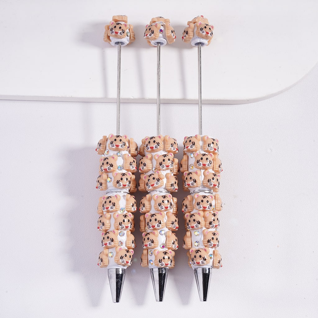 Three pens with decorative animal heads on a white background