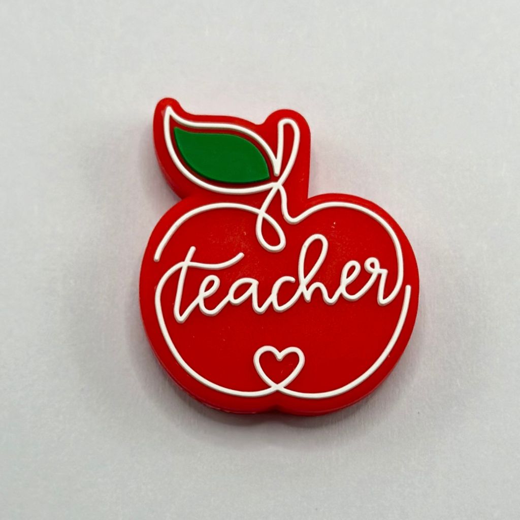 A red silicone bead in the shape of an apple with the word 'teacher' written in the center and a green leaf detail.