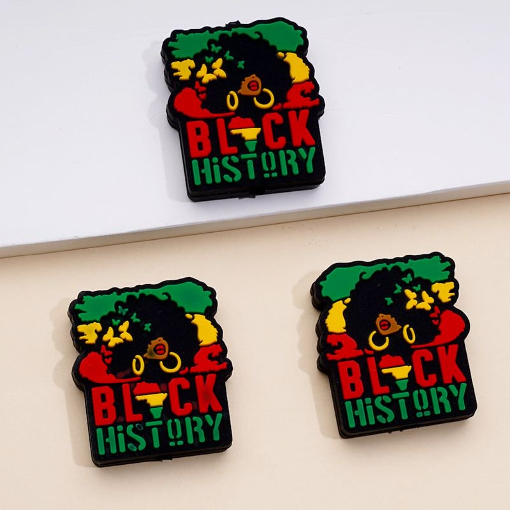 Silicone beads in the shape of a Juneteenth and Black History themed design, featuring the colors red, yellow, and green, and the text 'BLACK HISTORY'.