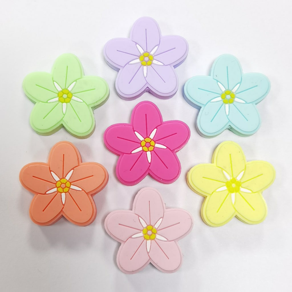A collection of colorful silicone beads shaped like five-petal flowers.