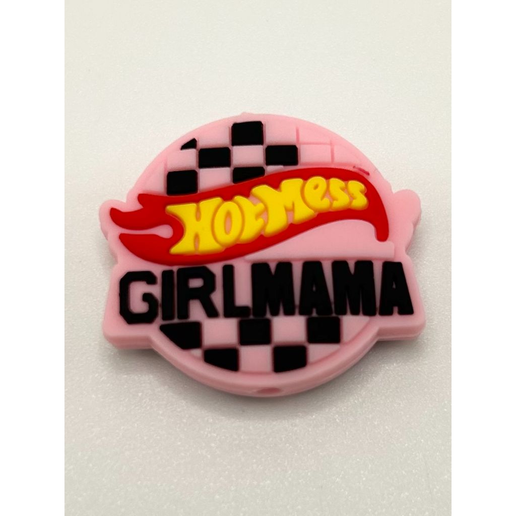 A silicone bead with the text 'HOT MESS GIRL MAMA' on a checkered pink and black background.