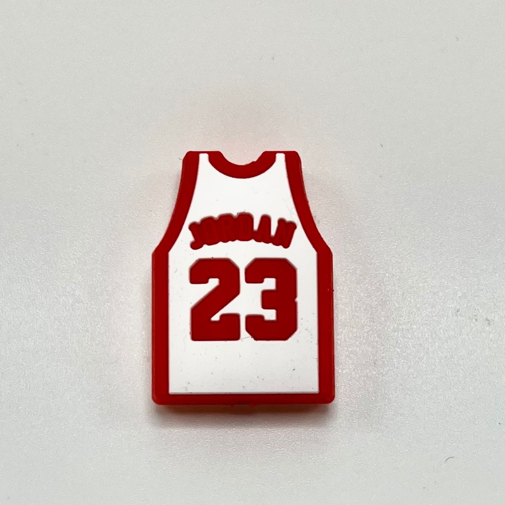 A silicone bead in the shape of a basketball jersey with the number 23 and the name 'JORDAN' on it.