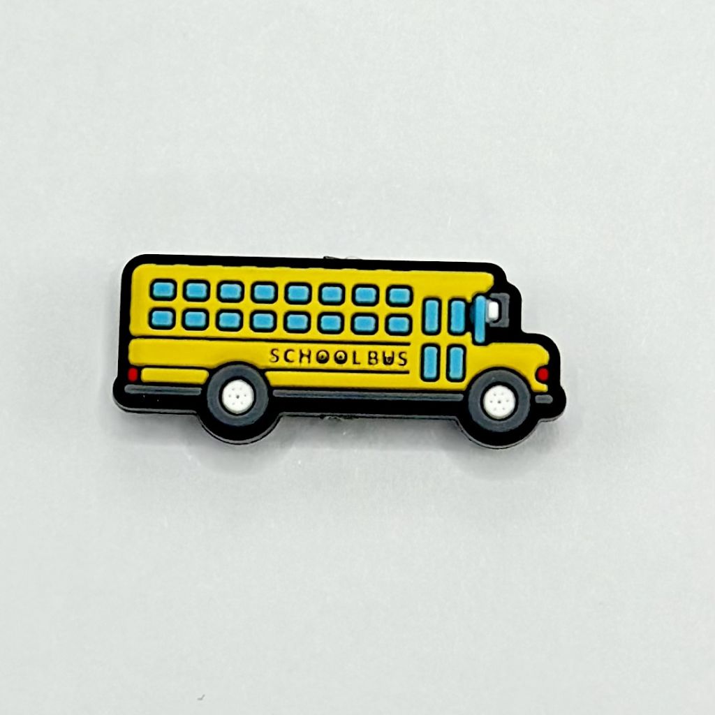 A silicone bead in the shape of a yellow school bus with blue windows and black detailing.