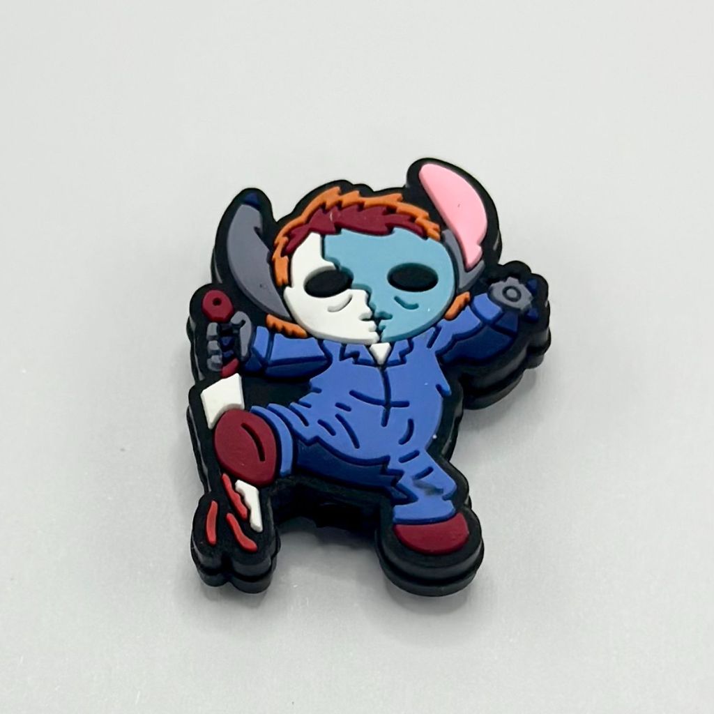 A silicone bead featuring a cartoon character with a blue face, wearing a multicolored hat and costume, holding a red apple.