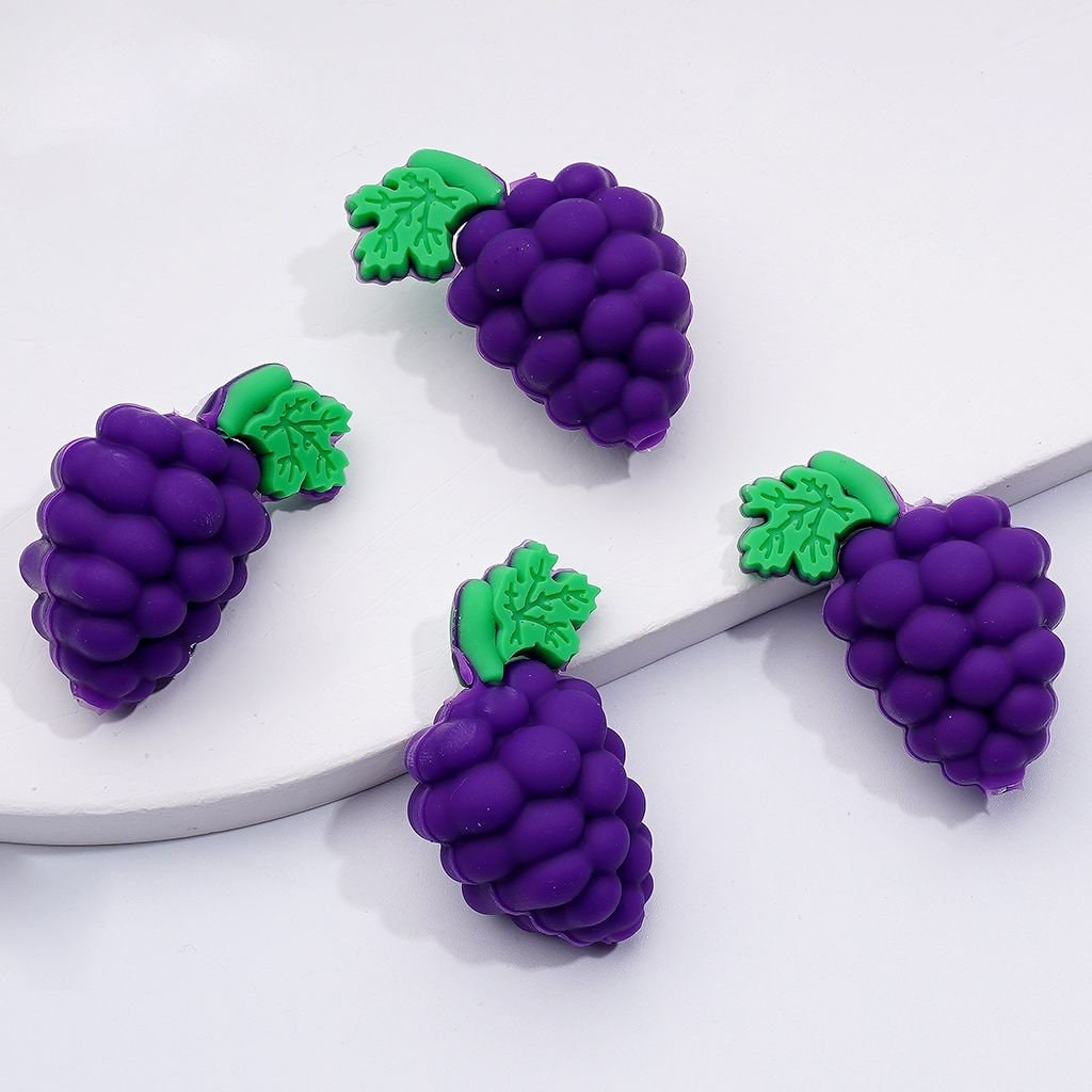 A set of purple silicone beads designed to look like grapes with green leaves.