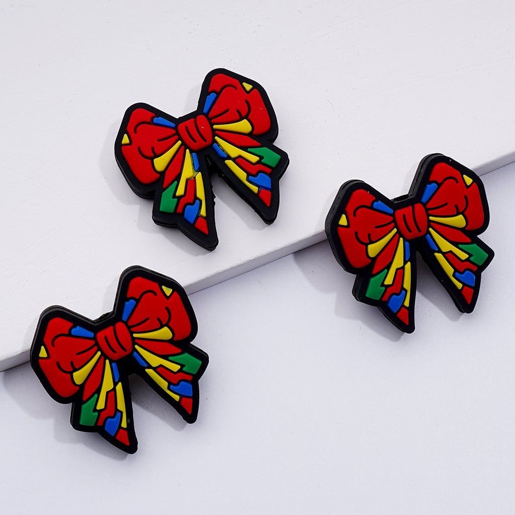 A set of silicone beads in the shape of colorful bowknots.