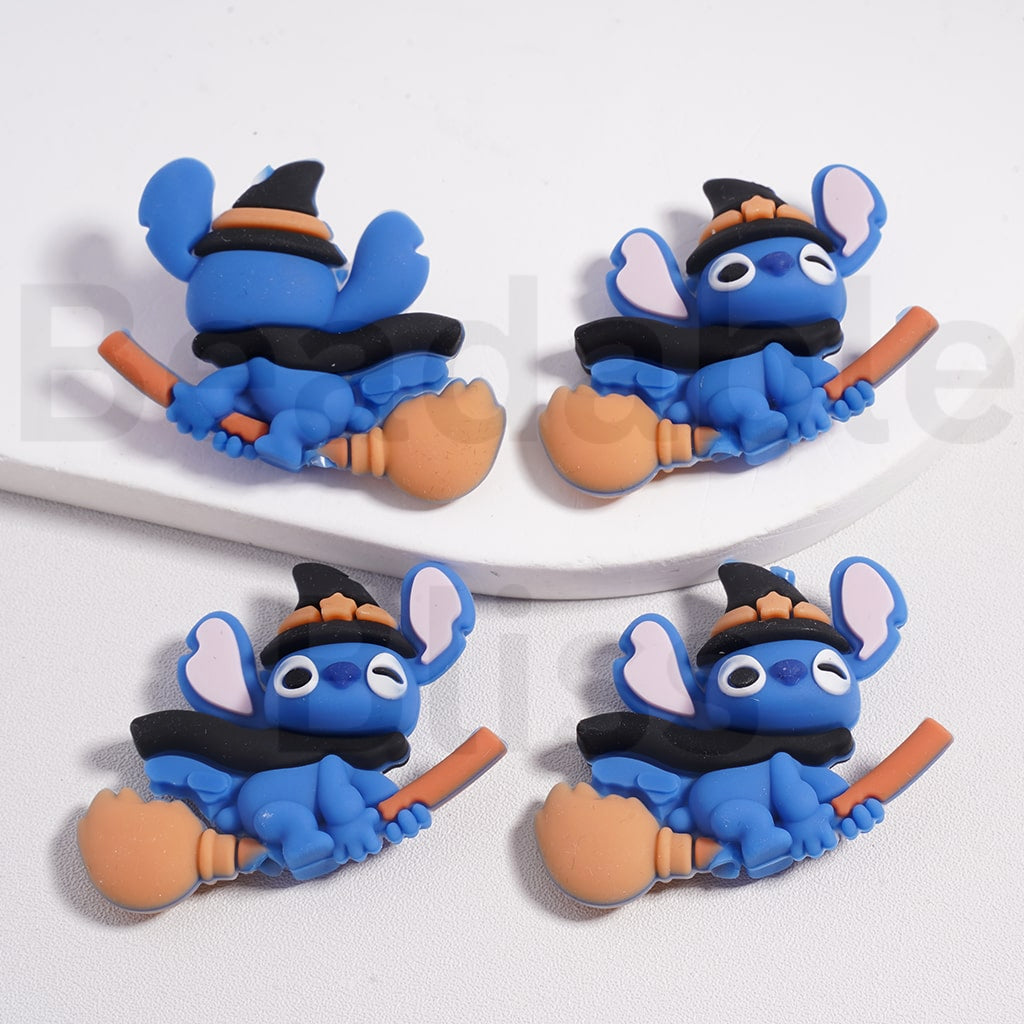 Four blue cartoon character figurines with black hats and orange sticks on a white background.