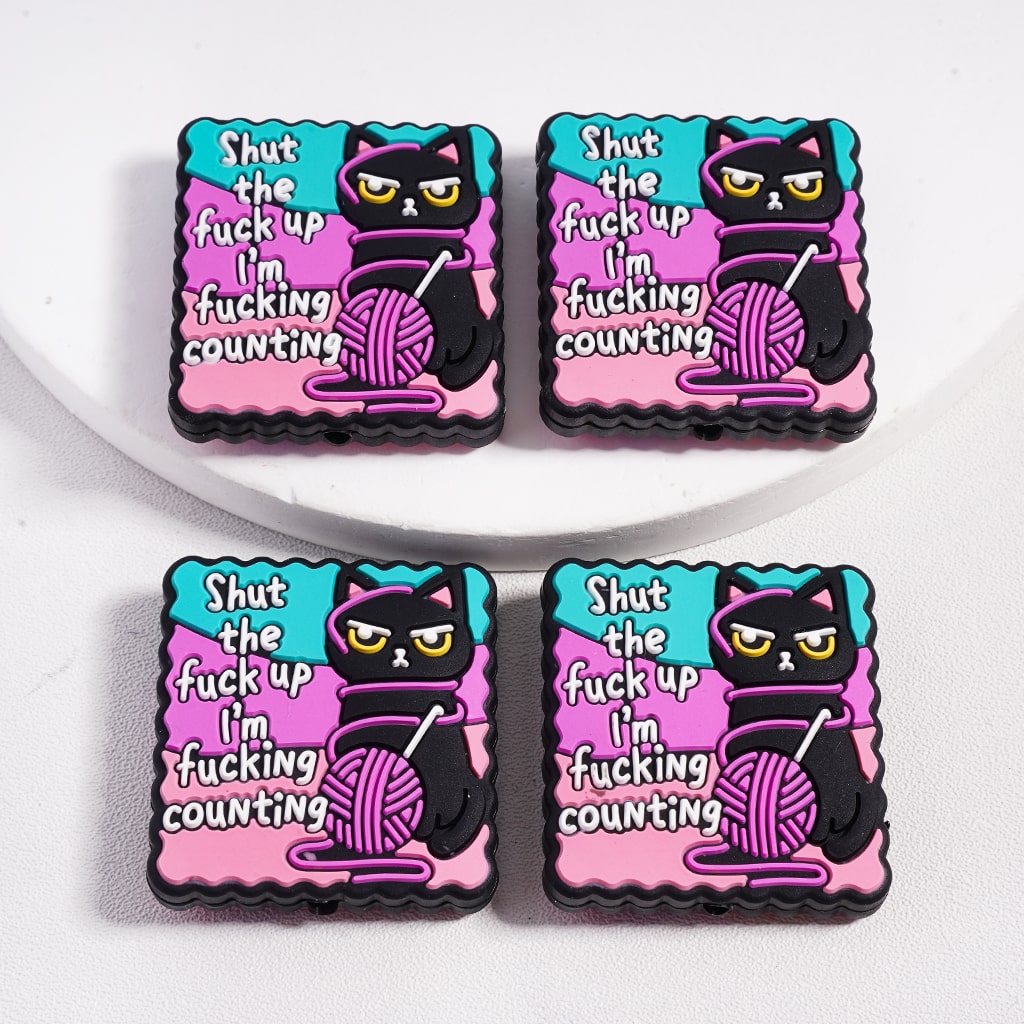 Four colorful pins with a black cat holding yarn and text on a white background