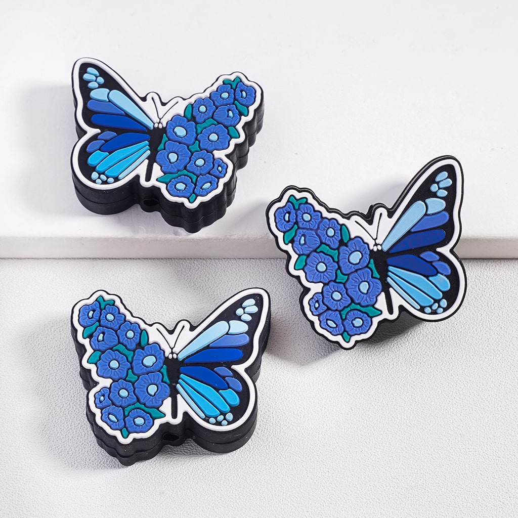 Three blue butterfly-shaped objects with floral patterns on a white background