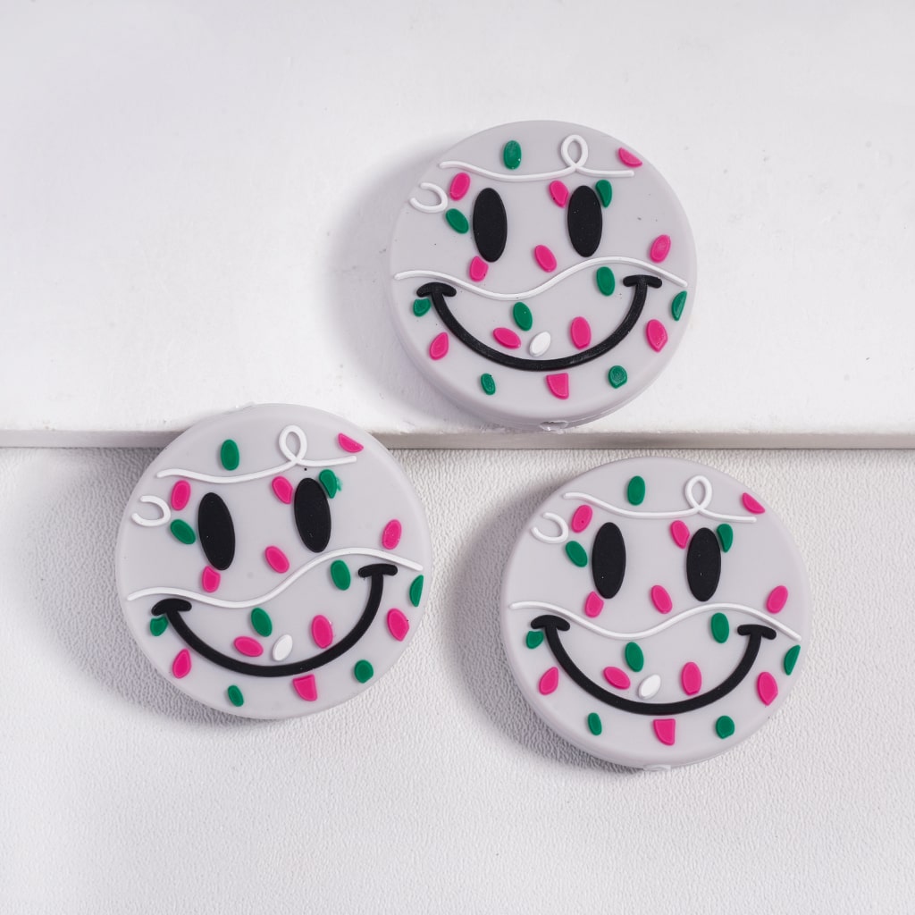 Three round buttons with smiley face designs on a white background