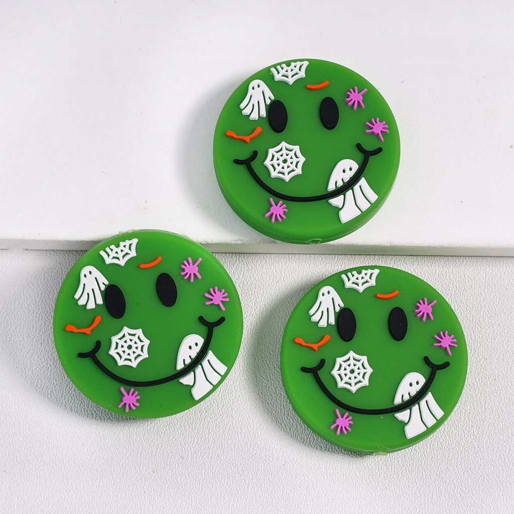 Three green circular cookies with Halloween-themed decorations on a white background