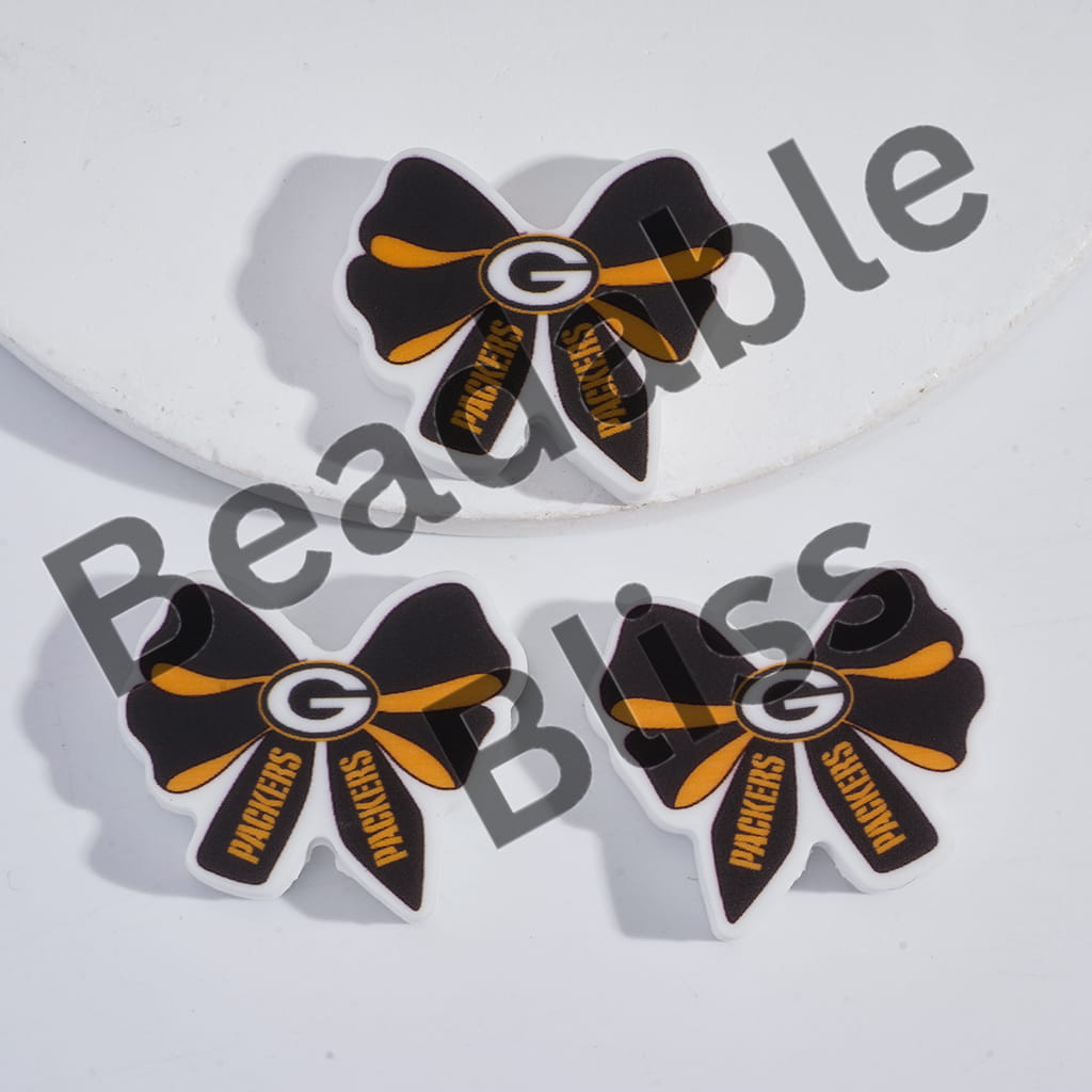 Packers-themed bow-shaped earrings on a white background with 'handsontosupply' branding.