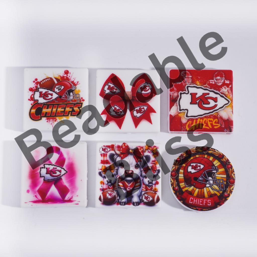 Collection of Kansas City Chiefs-themed items including stickers and a plush toy on a white background.
