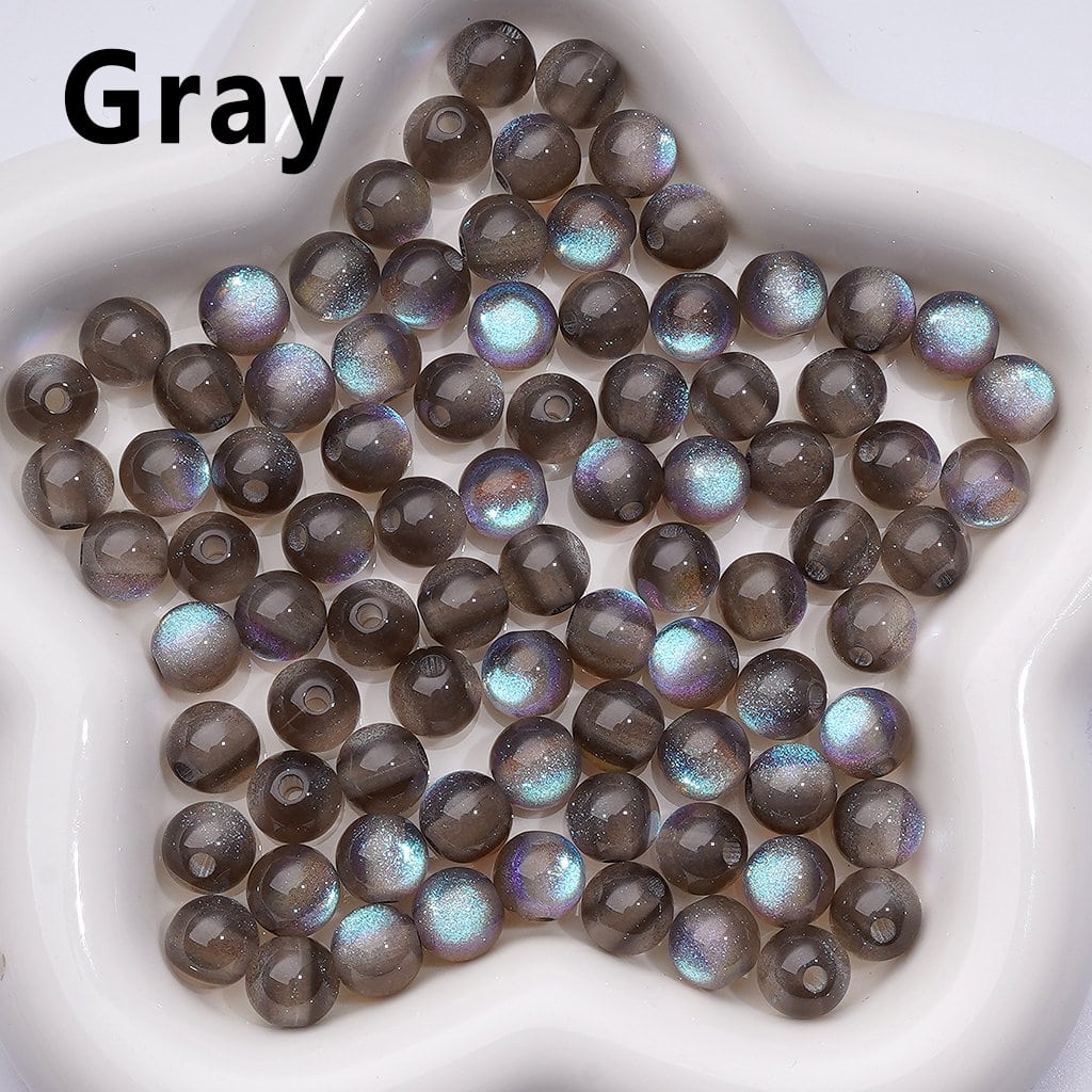 Gray beads with iridescent sheen on a white plate